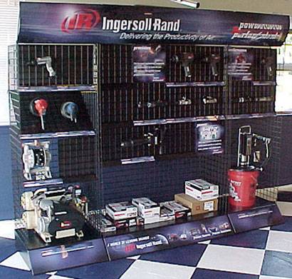 Ingersoll Rand display showcasing power tools, compressors, and accessories, neatly arranged on a grid-style stand with promotional branding.